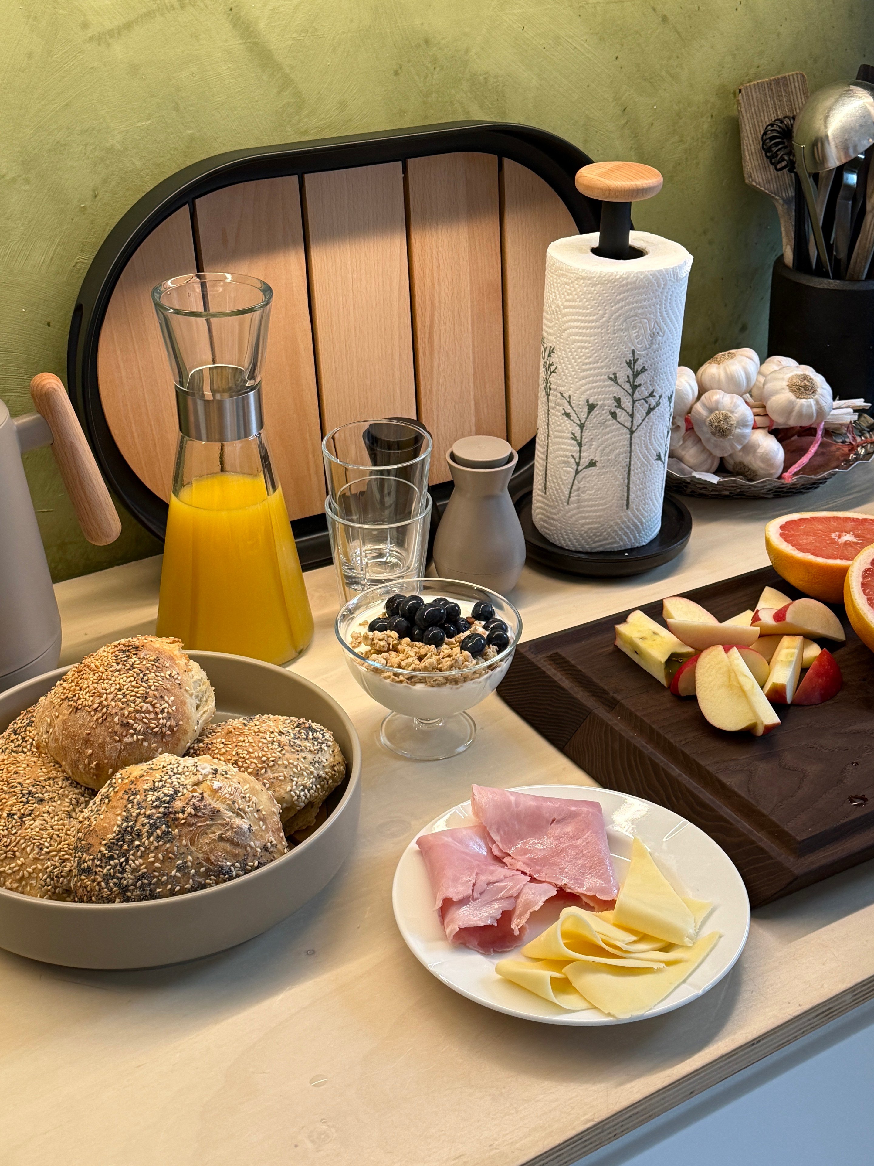 Morgenbord med nybagte rundstykker og Rosendahl servering i en rolig, enkel stemning