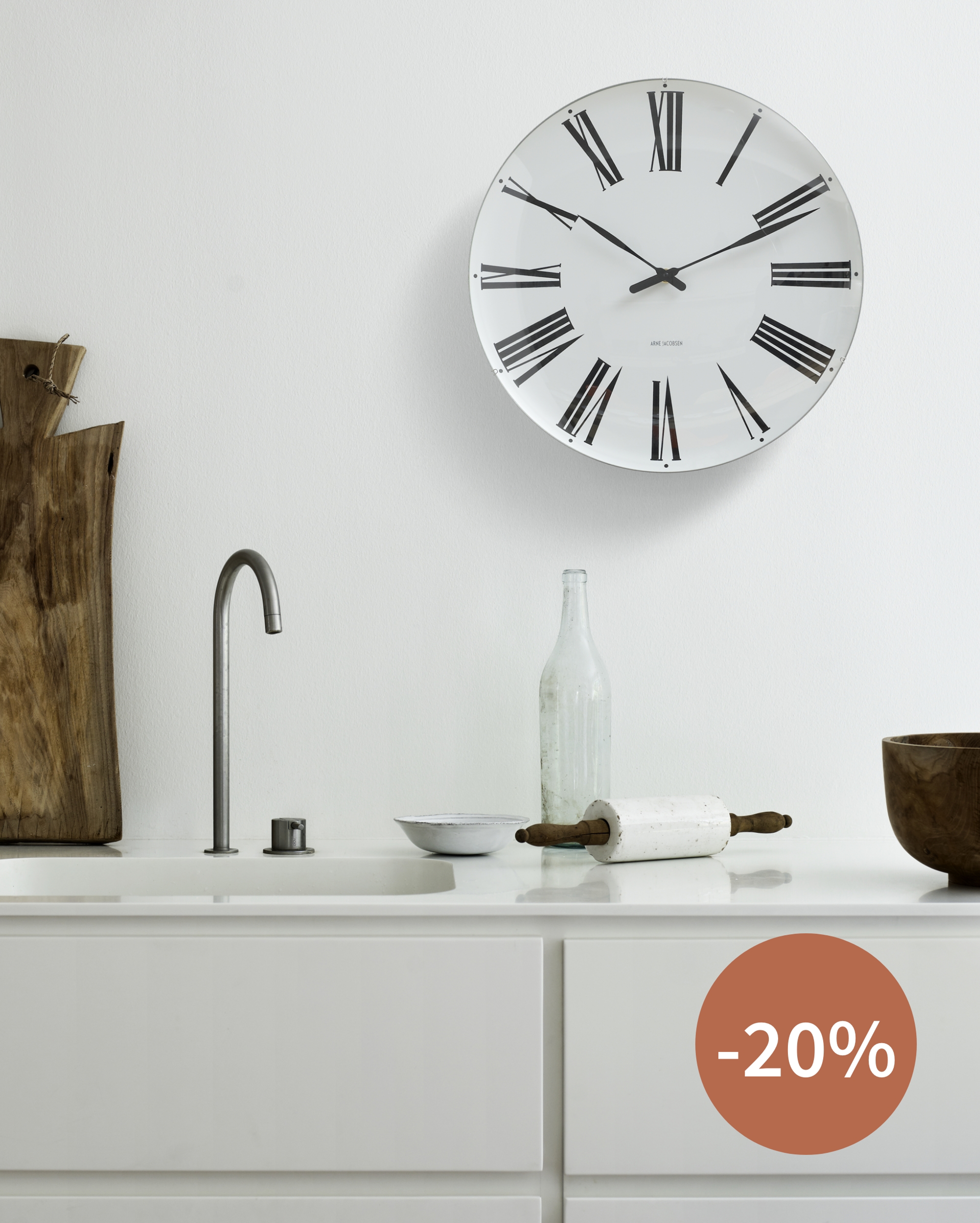 Arne Jacobsen Clocks vægur med romertal på hvid væg over skænk, ikonisk dansk design – Spar 20%