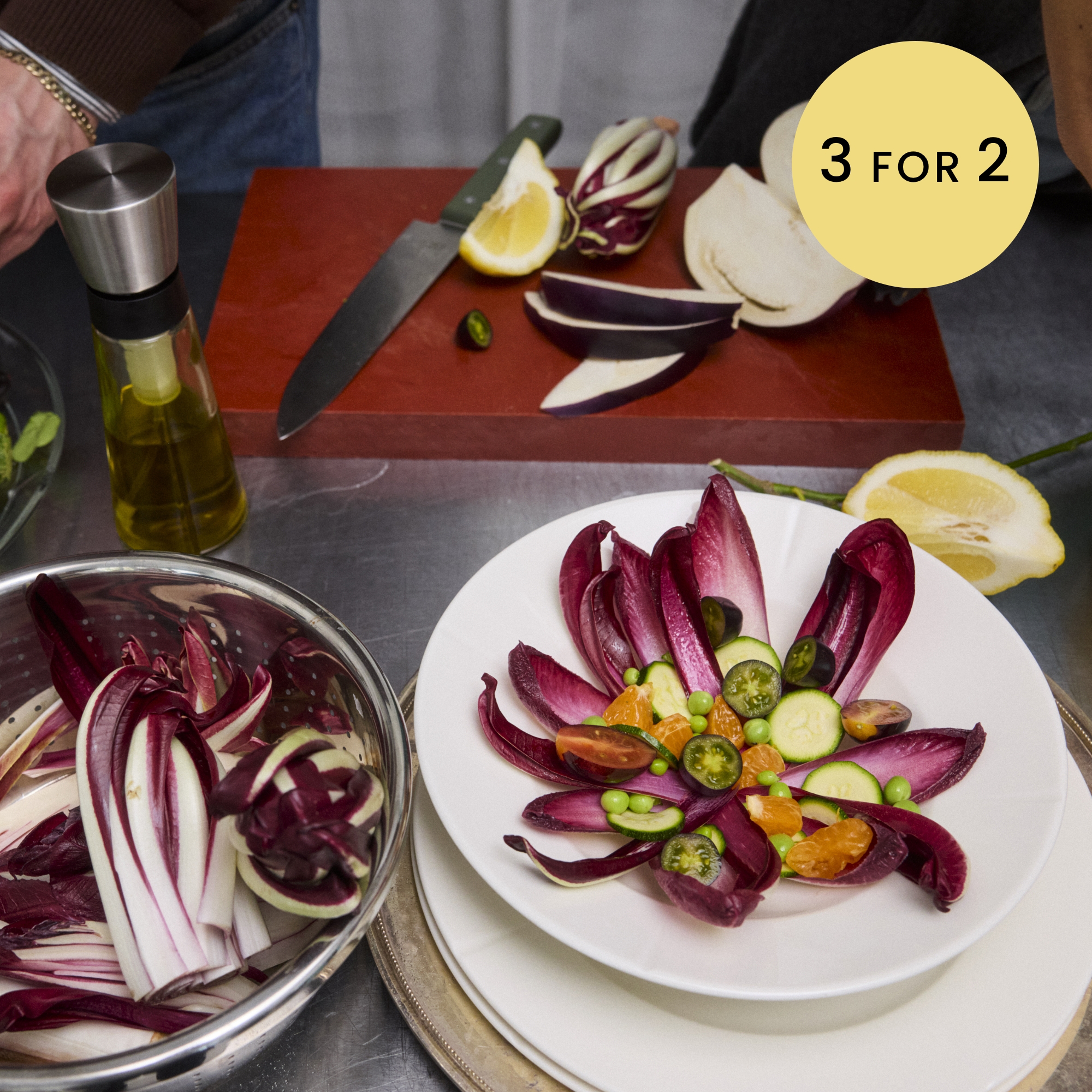 Rosendahl anretning med radicchio, sitrus og urter, oppskårne grønnsaker og olje på bord